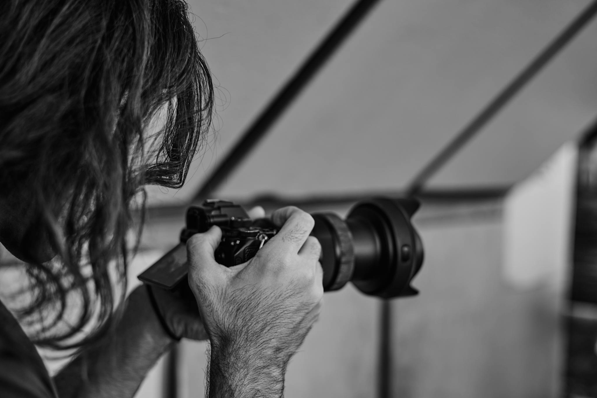 A focused photographer in action, capturing a moment in black and white.