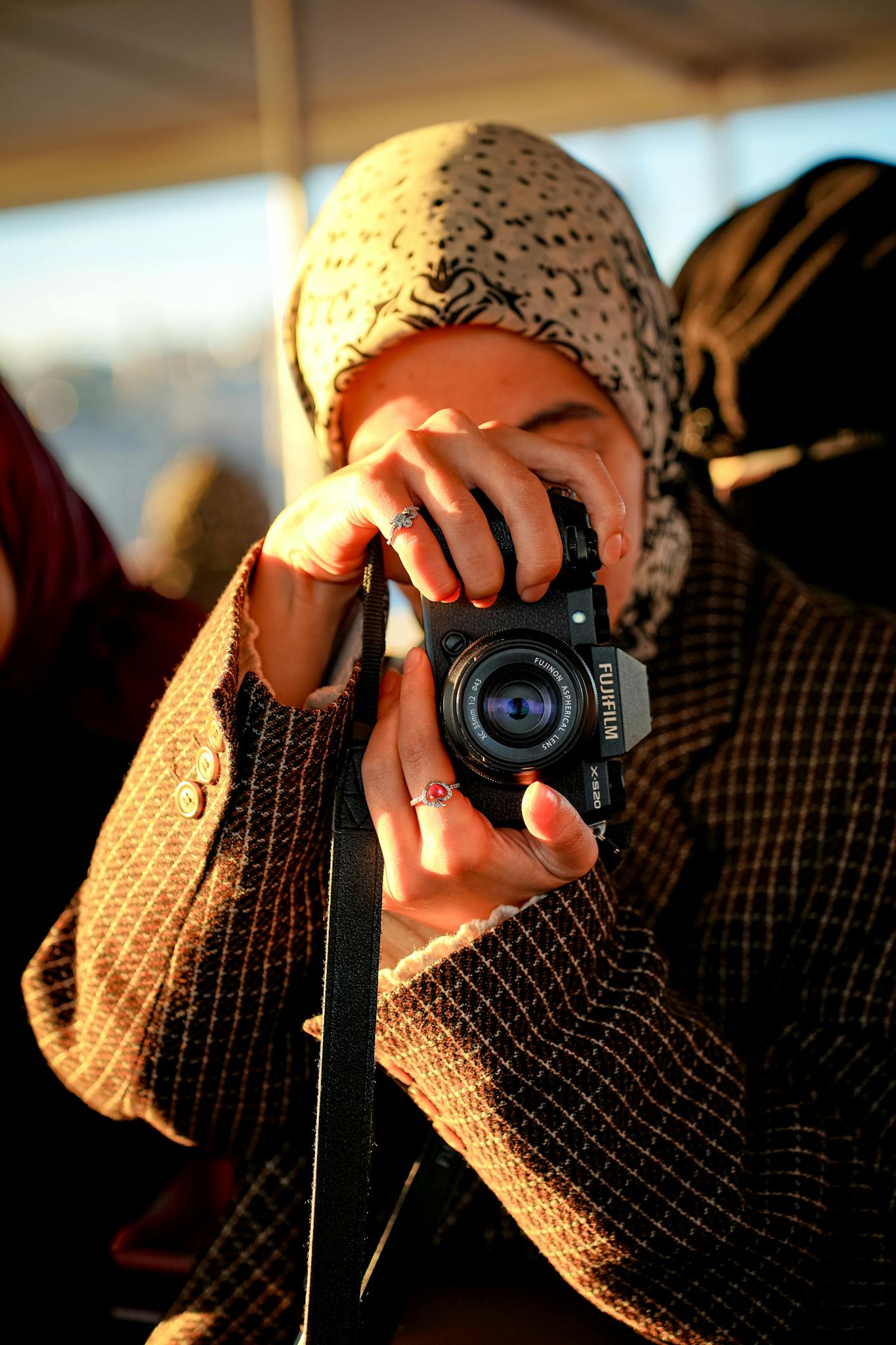 A woman with a camera captures the moment in a candid setting, surrounded by natural light.